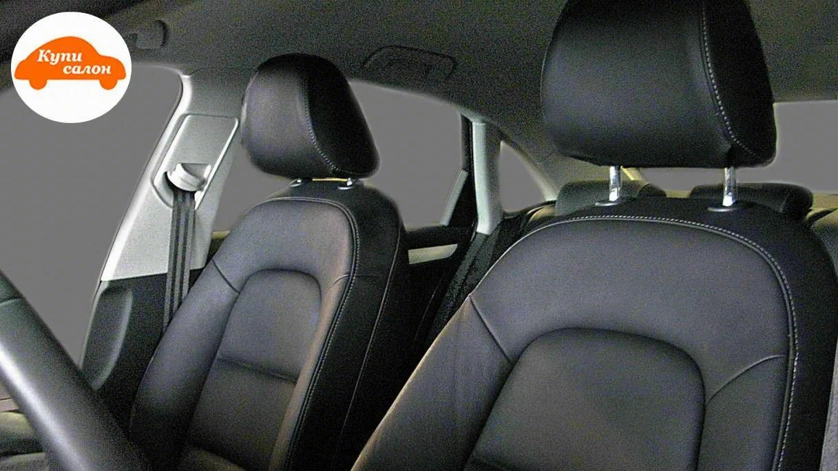 Перетяжка сидений и подголовников черной кожей с белой строчкой в салоне автомобиля