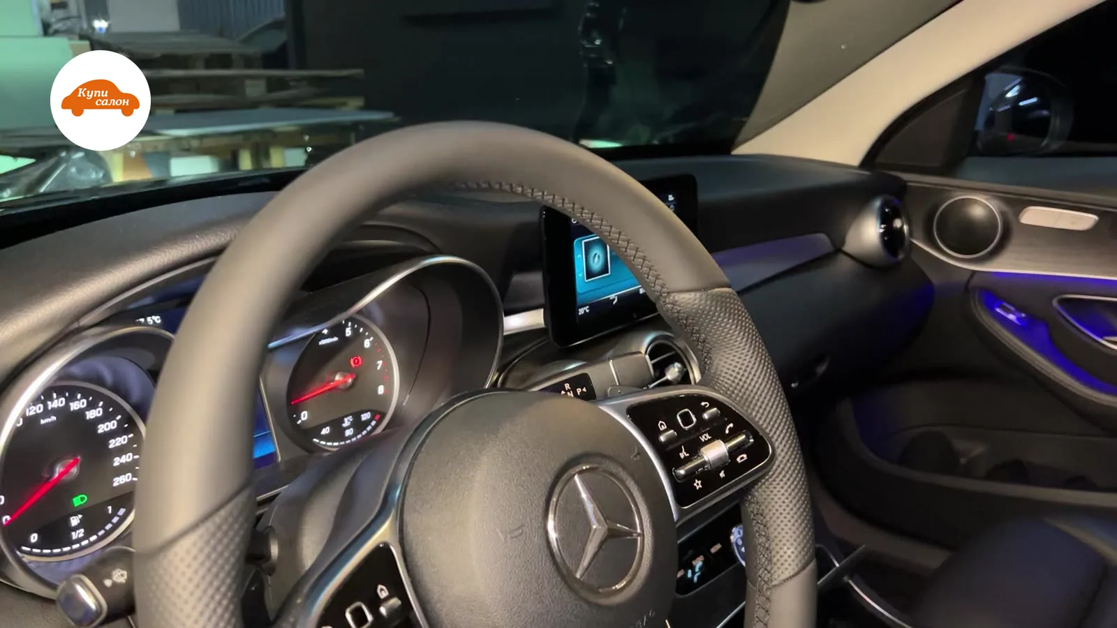 Интерьер Mercedes-Benz с перетянутым рулем из черной кожи с перфорацией и синей амбиентной подсветкой