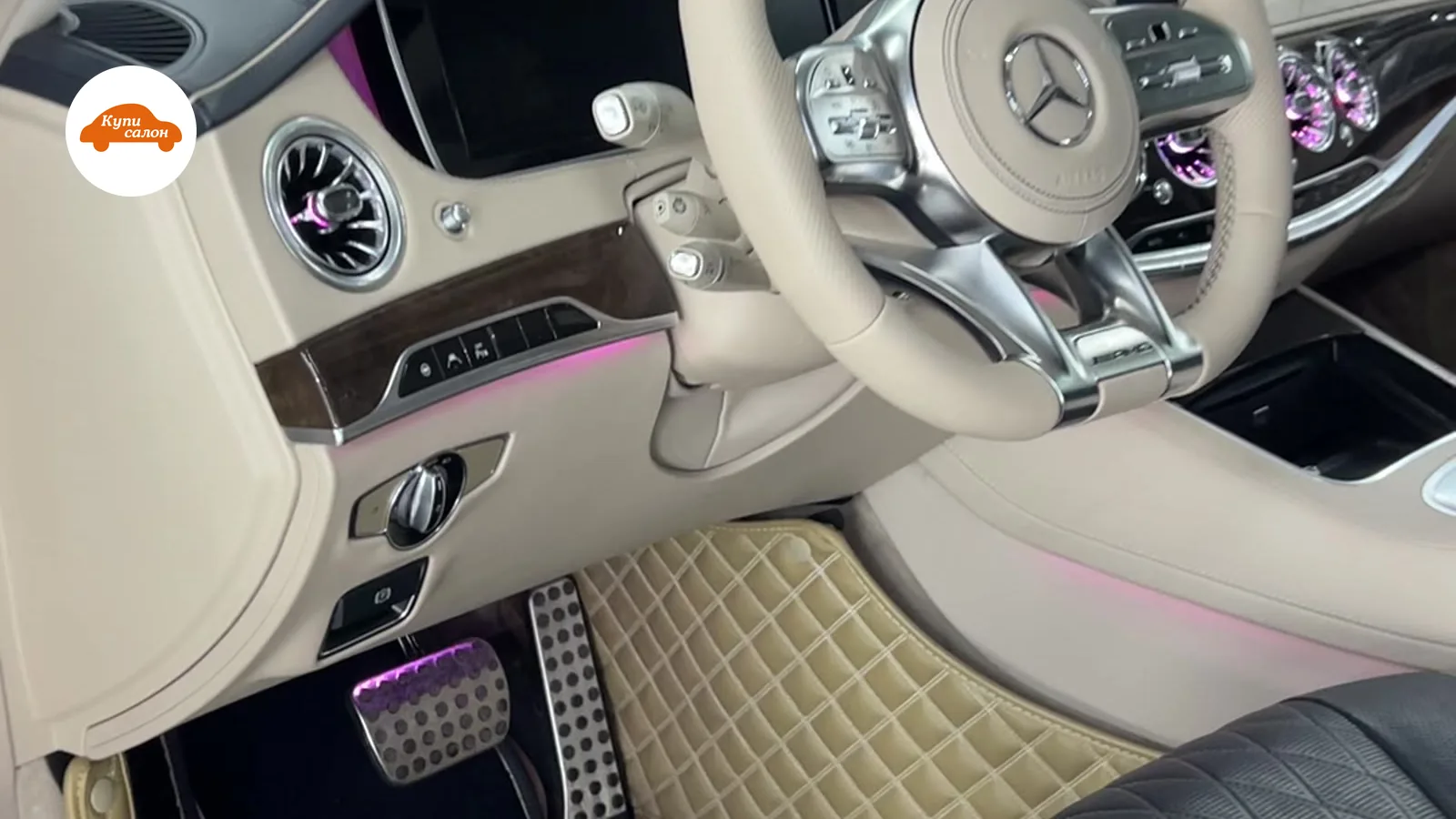 Интерьер Mercedes-Benz с перетяжкой сидений черной кожей, светлый руль, бежевые коврики, фиолетовая подсветка