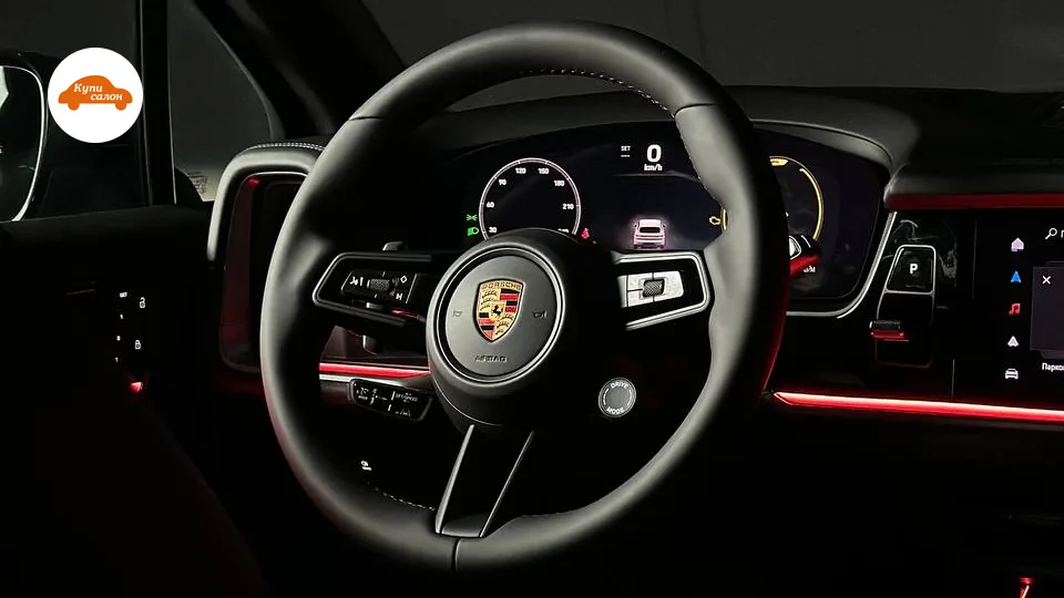 Интерьер Porsche с перетянутым черным кожаным рулем и красной амбиентной подсветкой