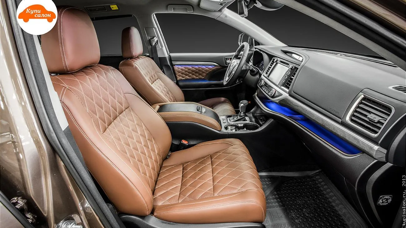 Перетяжка салона Toyota Highlander: сиденья и дверные вставки из коричневой кожи с ромбовидной прострочкой и перфорацией, амбиентная подсветка.