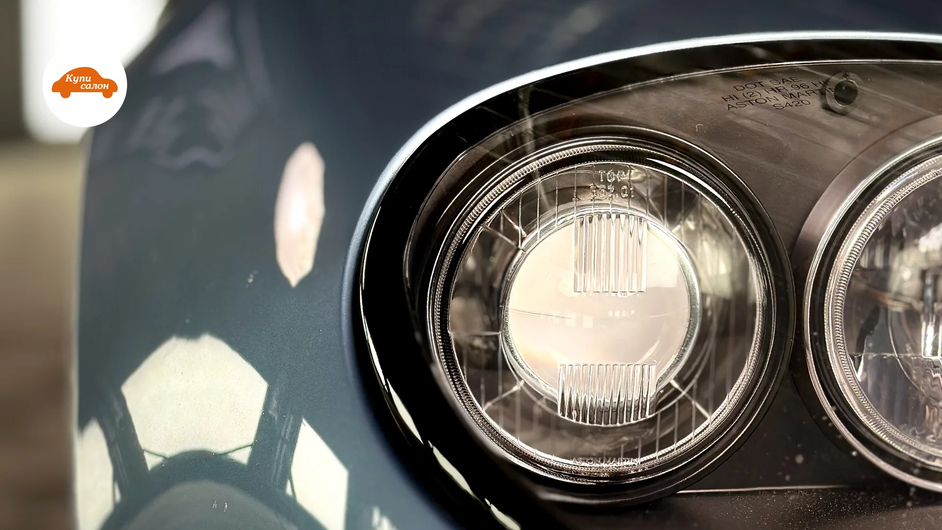 Фара автомобиля Aston Martin, крупный план, чистая и блестящая.