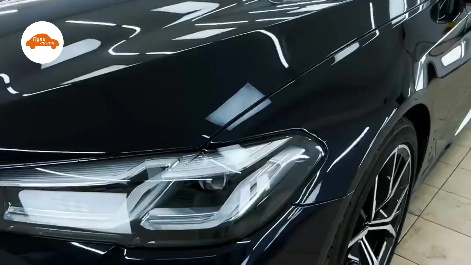 Черный автомобиль BMW с глянцевым кузовом после оклейки защитной пленкой или полировки.