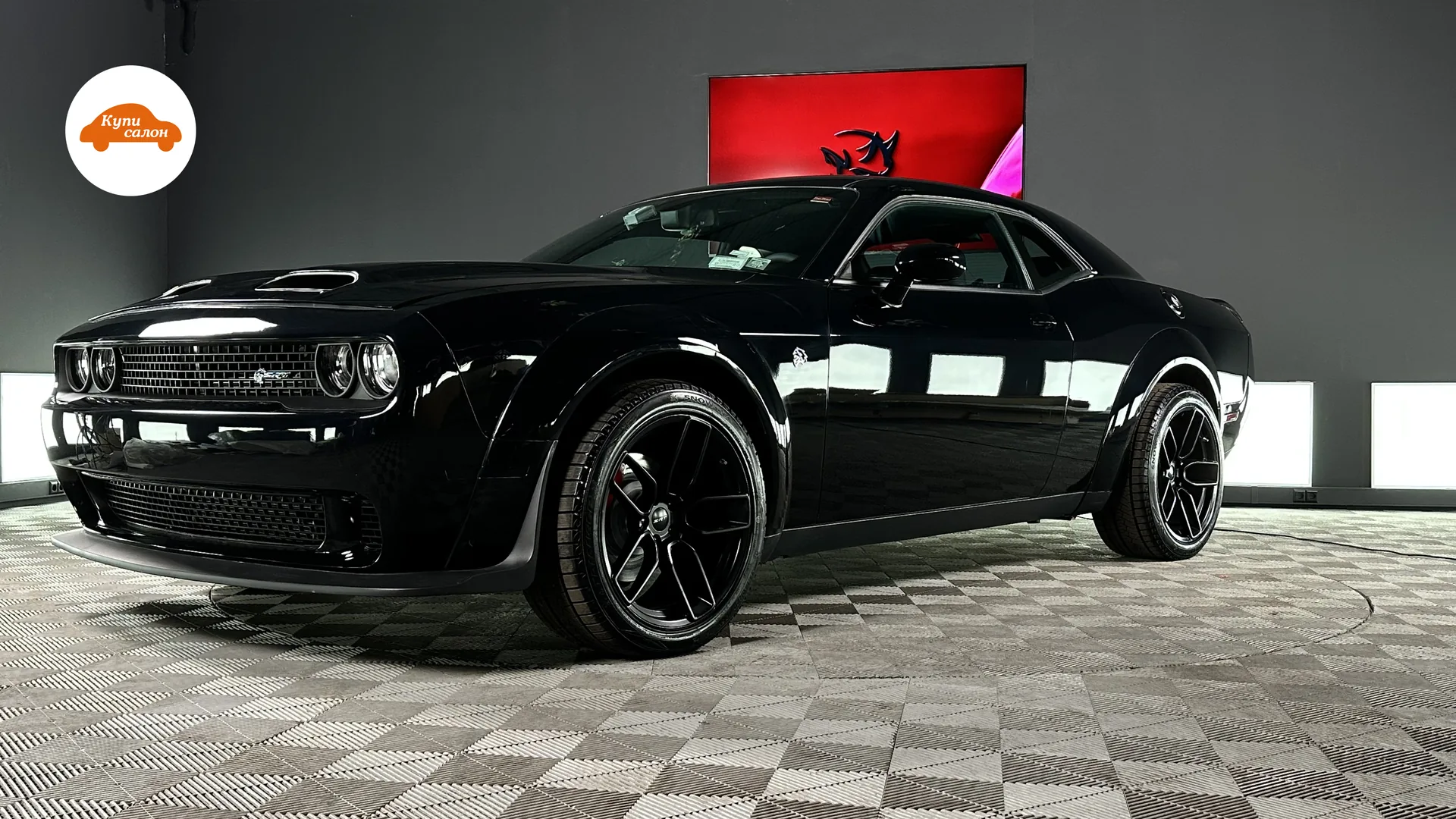 Черный Dodge Challenger, вид спереди сбоку, на полу с шахматным узором