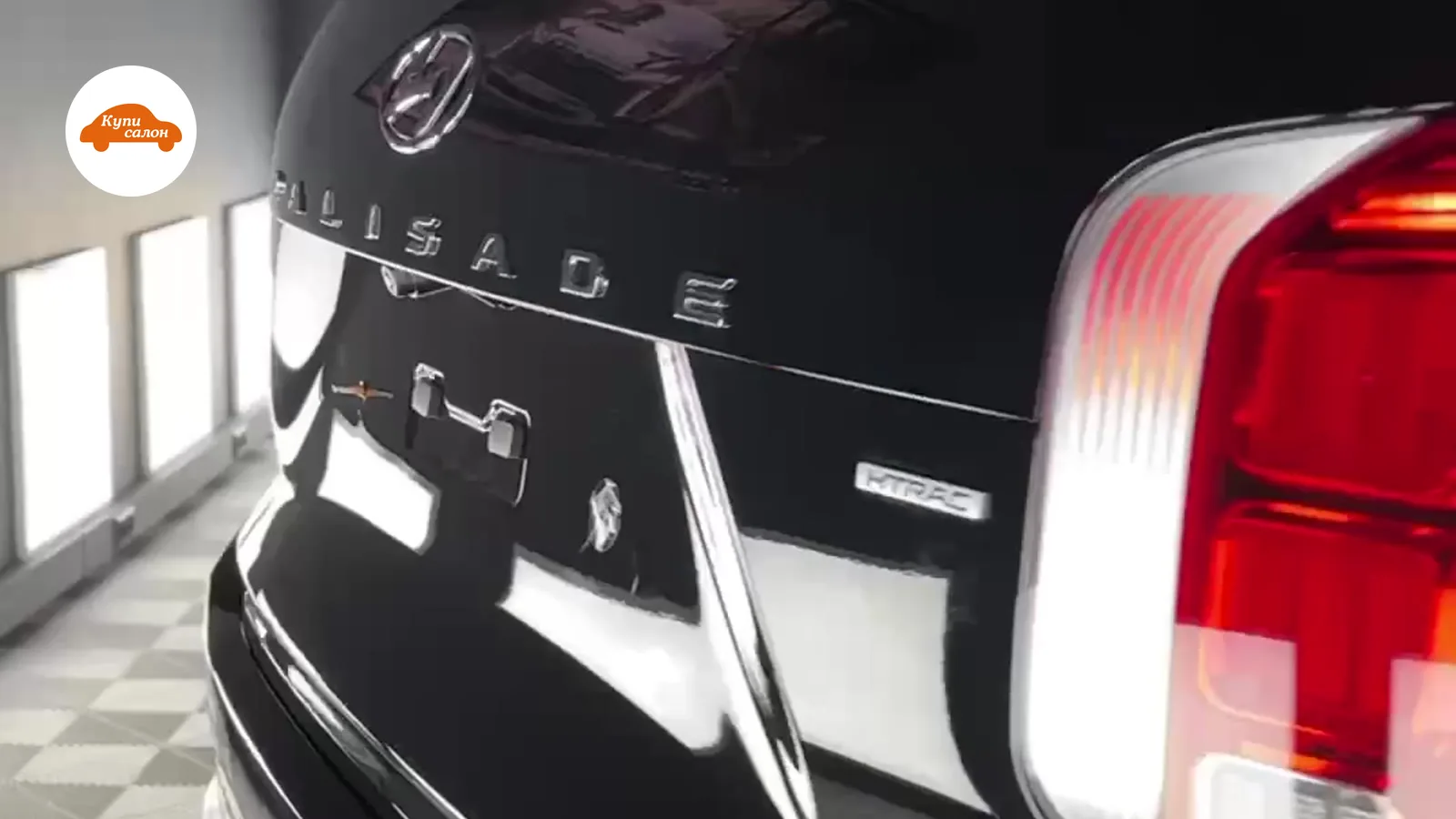 Задняя часть черного Hyundai Palisade с защитной пленкой на багажнике и бампере, полированные фонари.