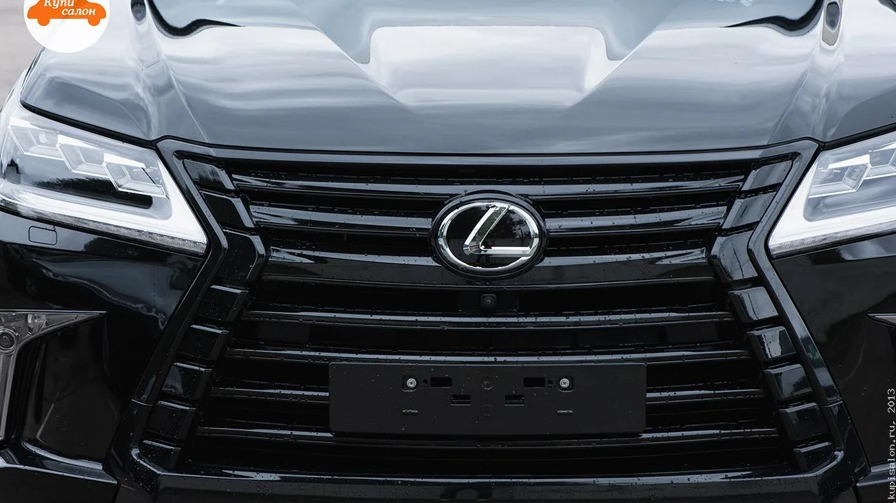 Передняя часть черного автомобиля Lexus, вид спереди на решетку радиатора и фары.