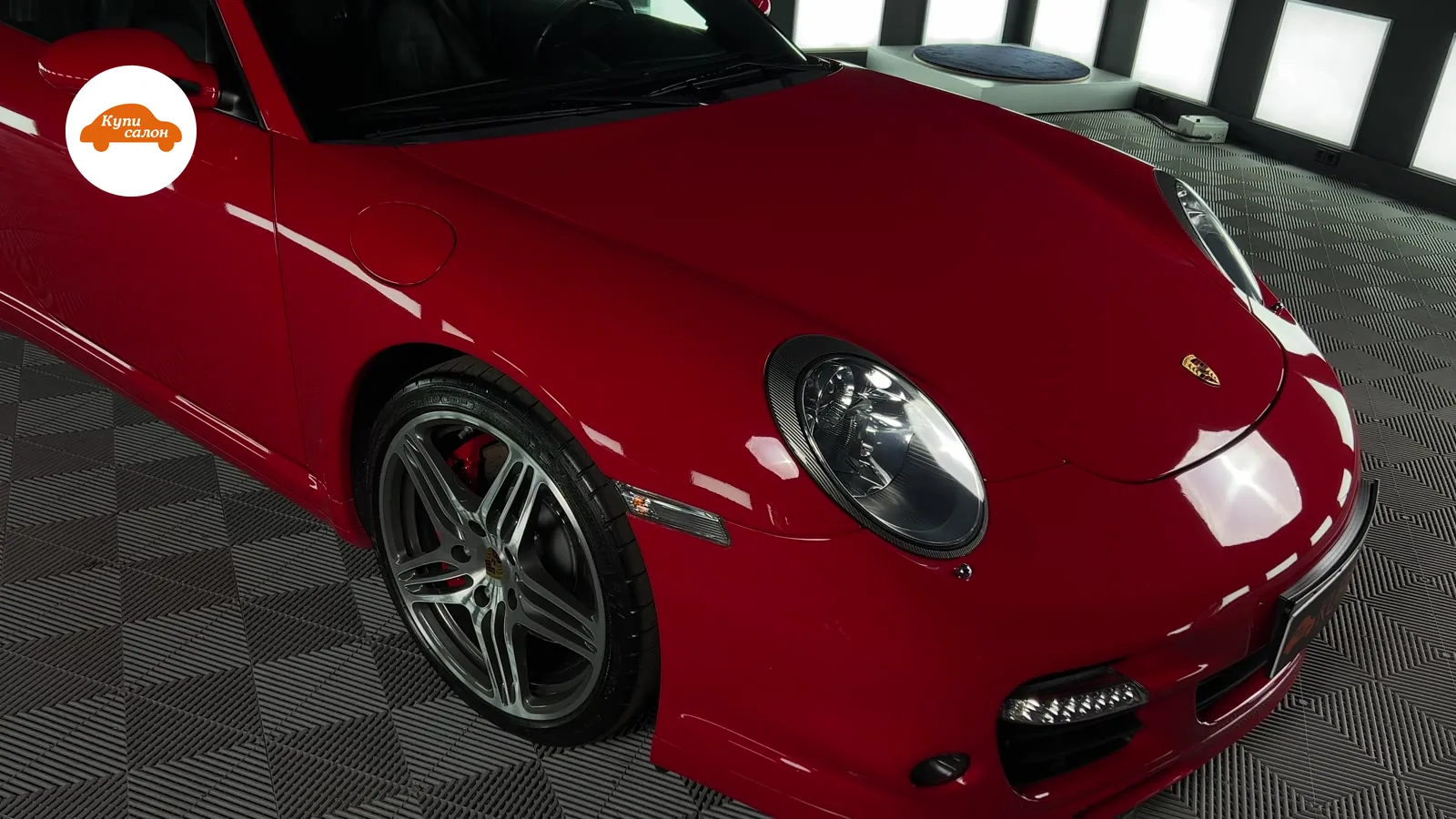 Красный Porsche с защитной пленкой на кузове, вид спереди-сбоку. Детейлинг.
