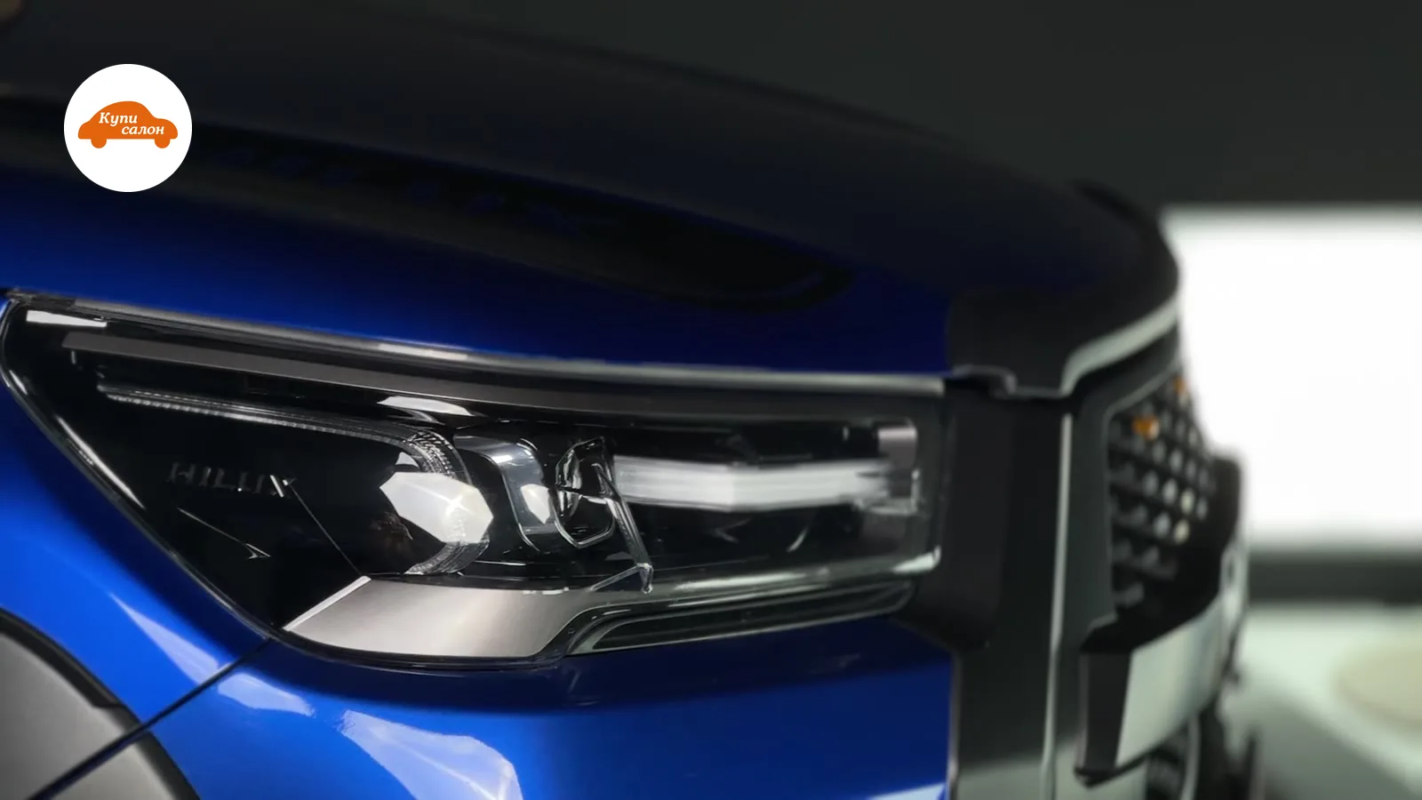 Крупный план фары синего пикапа Toyota Hilux с защитной пленкой