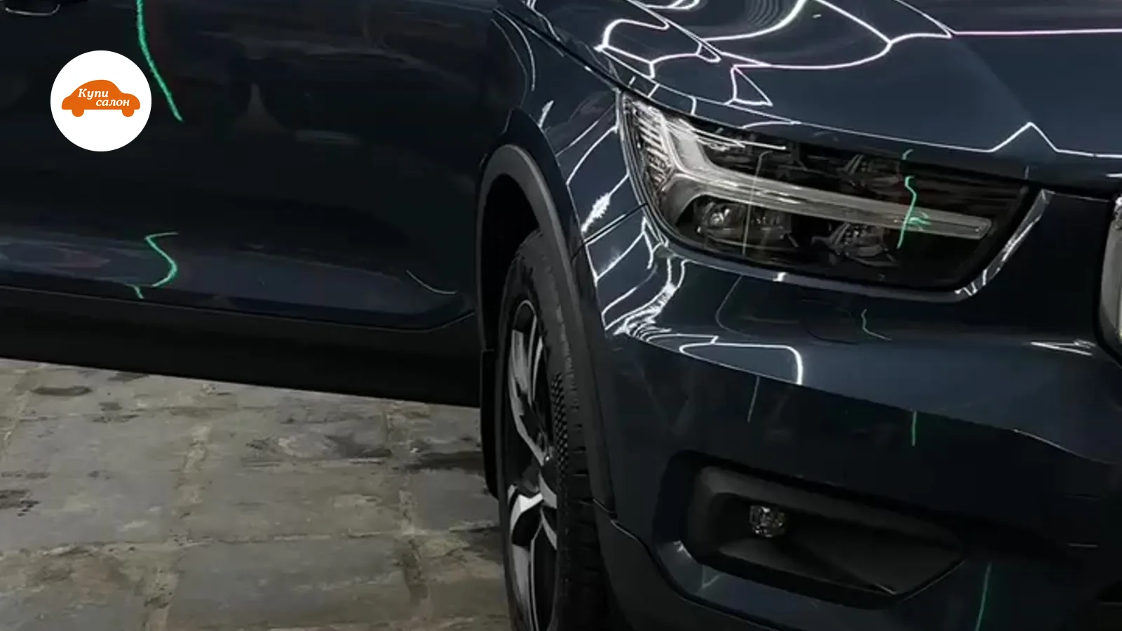 Оклейка защитной пленкой автомобиля Volvo темного цвета, вид спереди с открытой дверью.