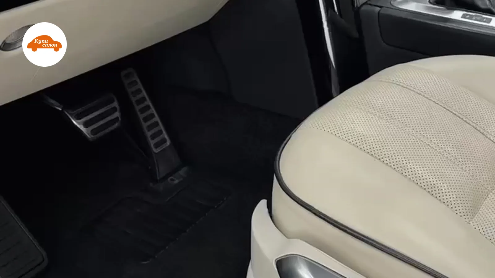 Интерьер Land Rover с перетяжкой сидений бежевой перфорированной кожей и черным рулем.