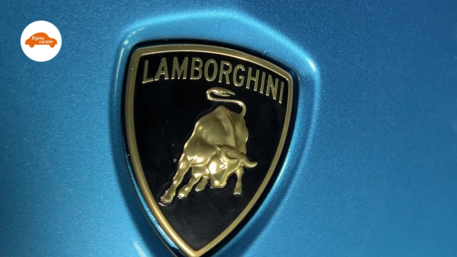Шильдик Lamborghini на синем кузове автомобиля