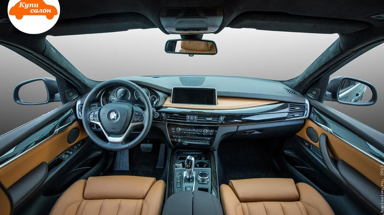 Интерьер BMW с перетяжкой салона в коричневую кожу и черные элементы, включая сиденья, руль, дверные карты и торпедо.