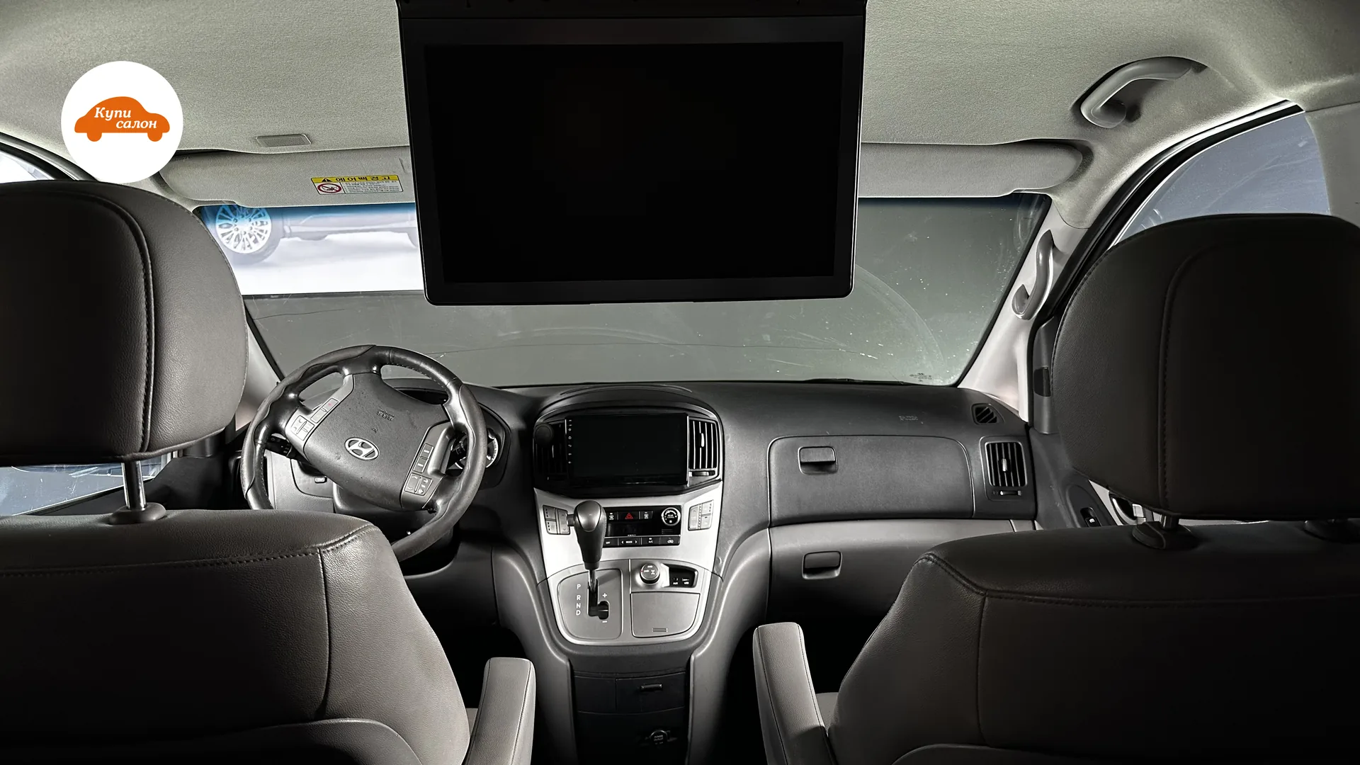 Интерьер Hyundai H-1, вид с заднего ряда, черная кожа на сиденьях и руле, светлый потолок
