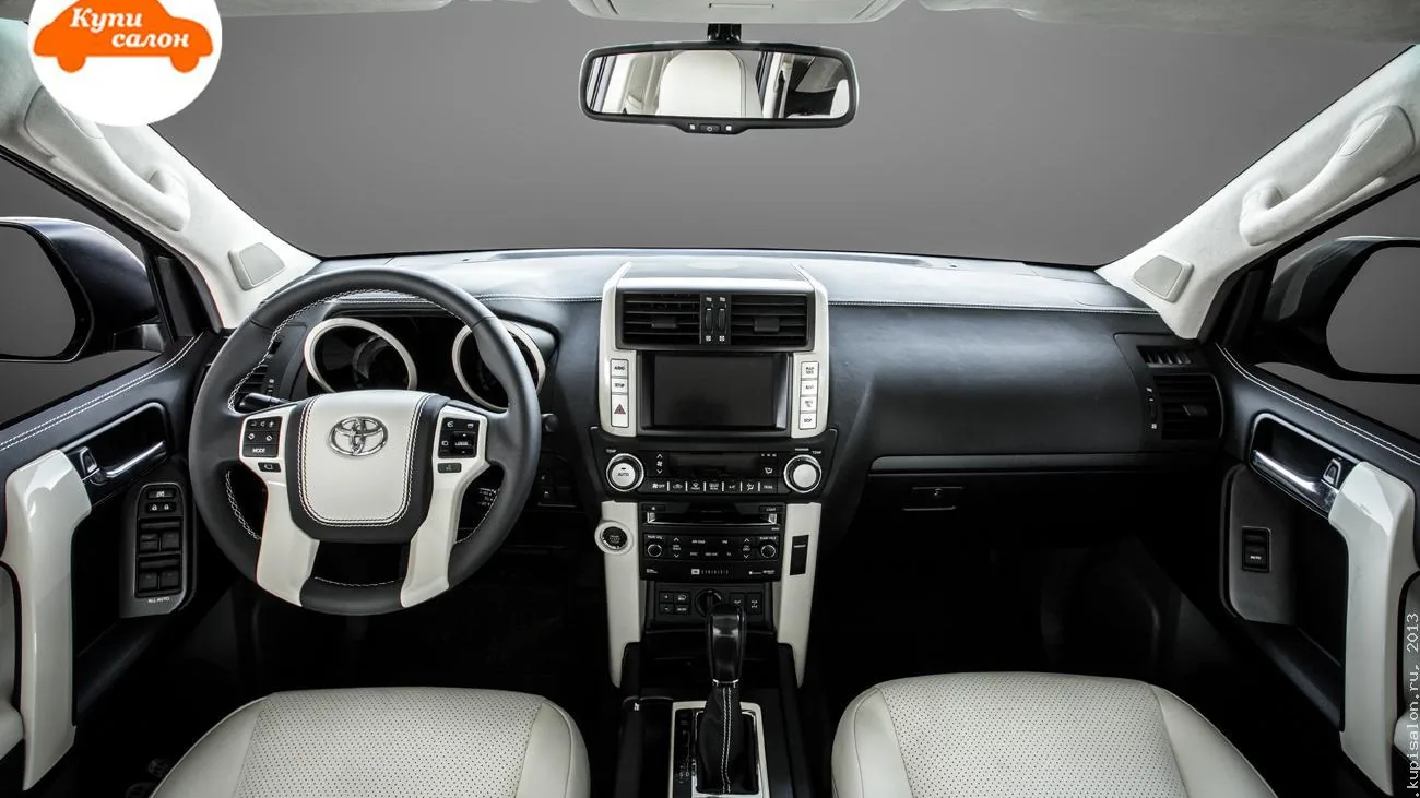 Toyota Land Cruiser Prado 150: чёрное торпедо после перетяжки, белые накладки консоли и руля, светлые сиденья — работа КупиСалон