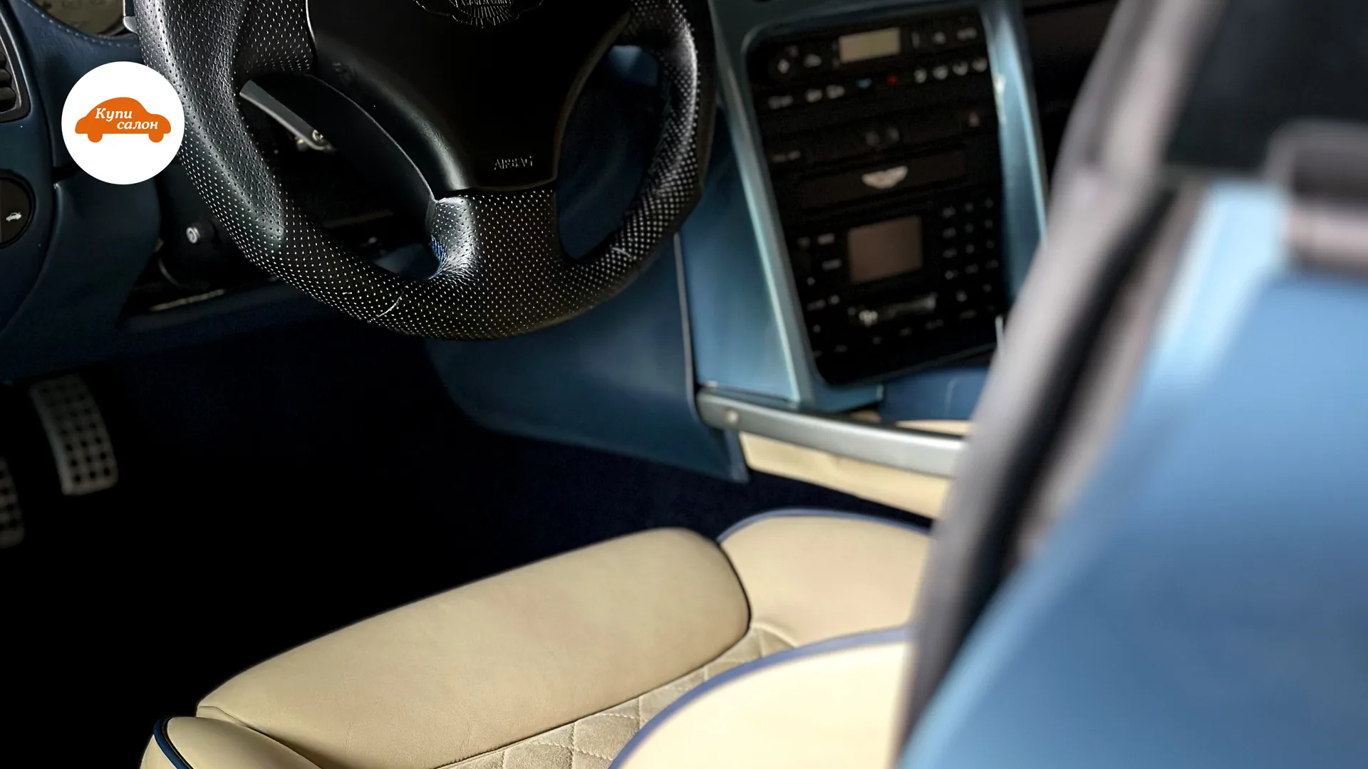 Перетяжка руля и сидений Aston Martin в светлой коже с синим кантом и ромбовидной строчкой