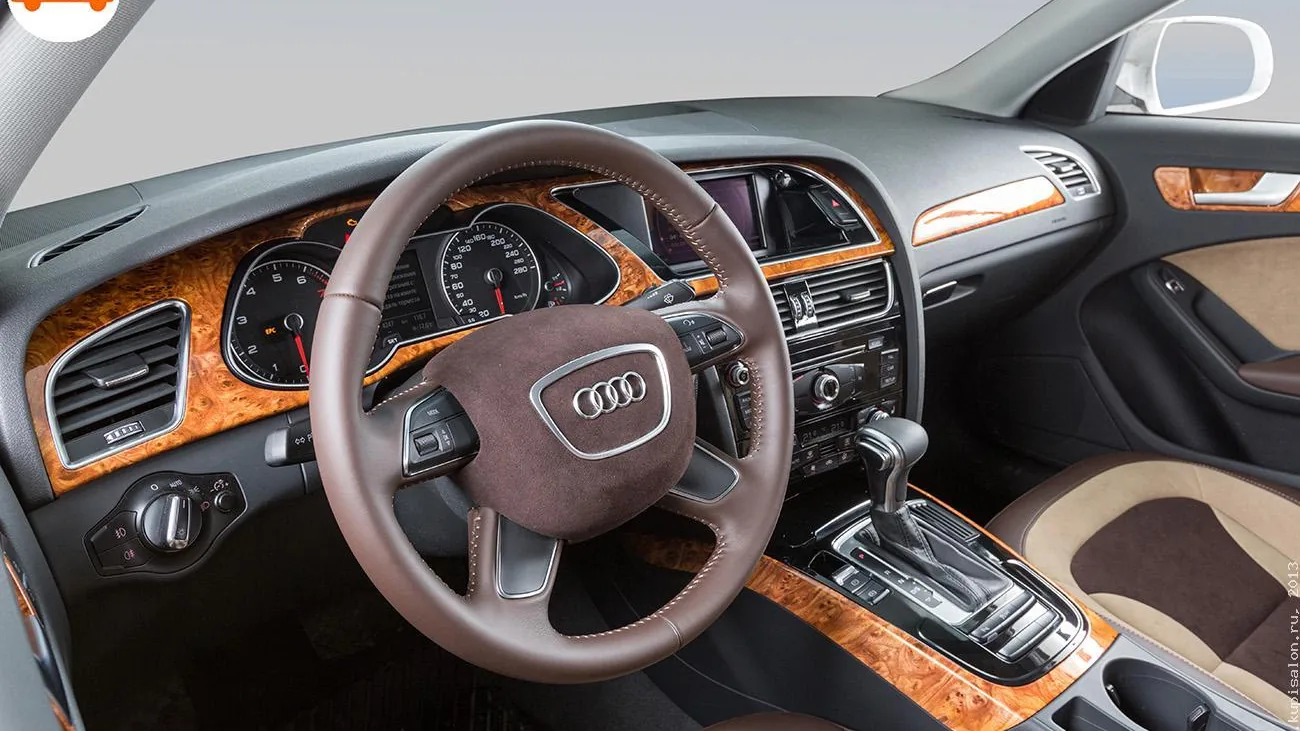 Интерьер Audi с перетянутым рулем из коричневой кожи и замши, сиденьями из коричневой и бежевой кожи, деревянными вставками