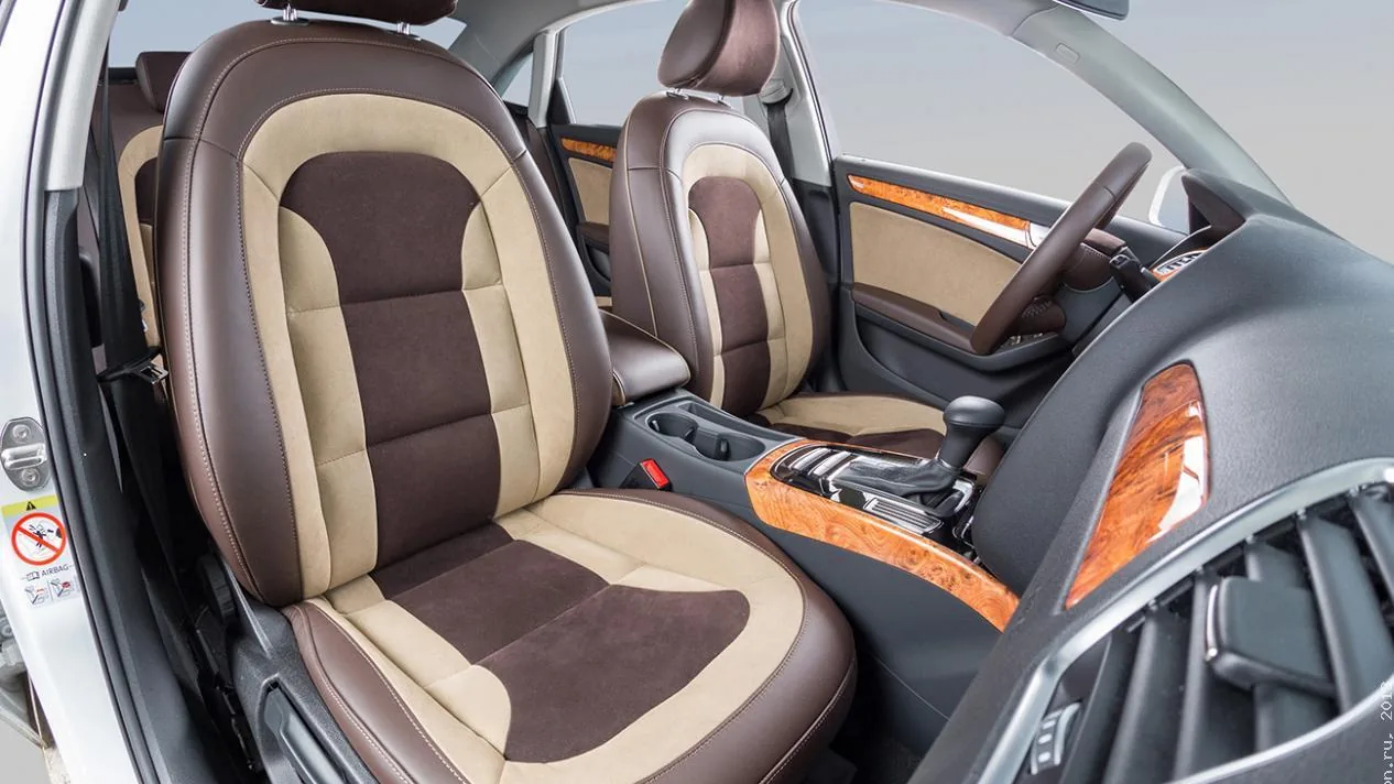 Перетяжка салона Audi: сиденья из экокожи коричневого и бежевого цвета, руль и подлокотник коричневые, вставки под дерево