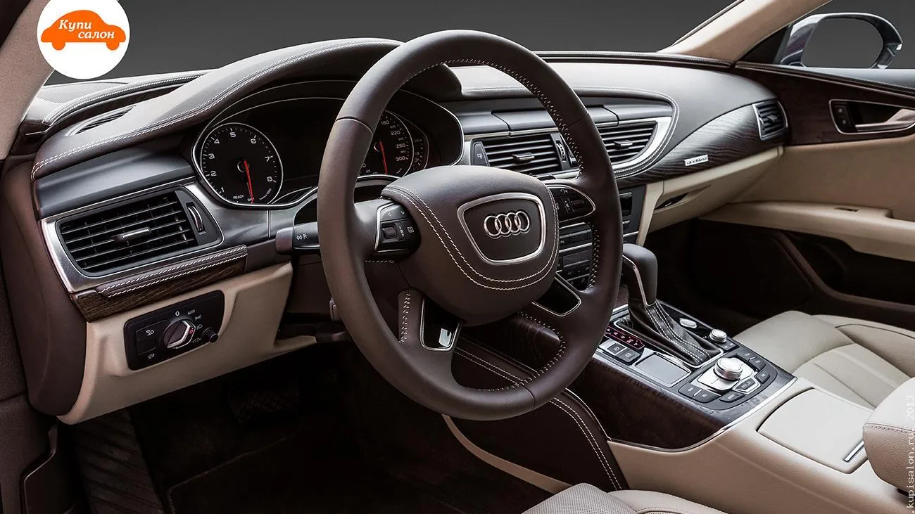 Интерьер Audi, перетяжка руля, торпедо и центральной консоли коричневой кожей с белой строчкой, деревянные вставки.