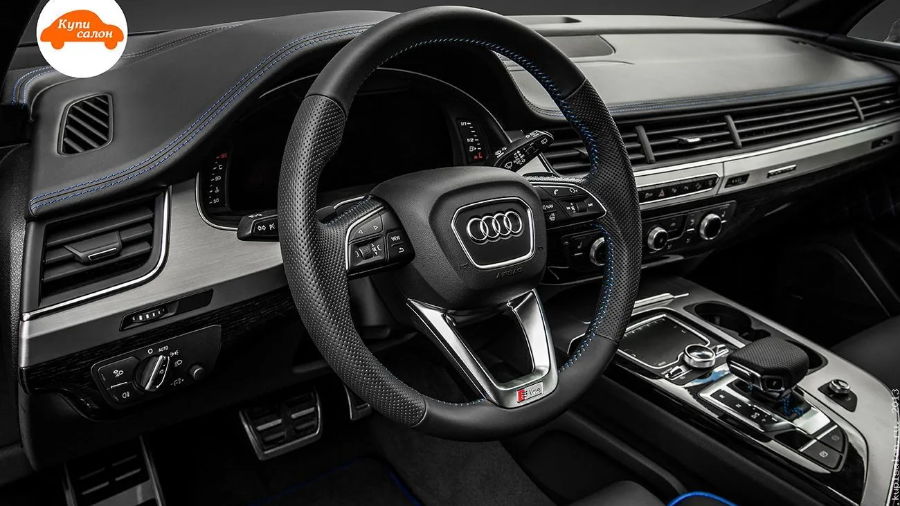 Интерьер Audi с перетяжкой руля и торпеды черной кожей с синей строчкой, а также ковриками с синей окантовкой
