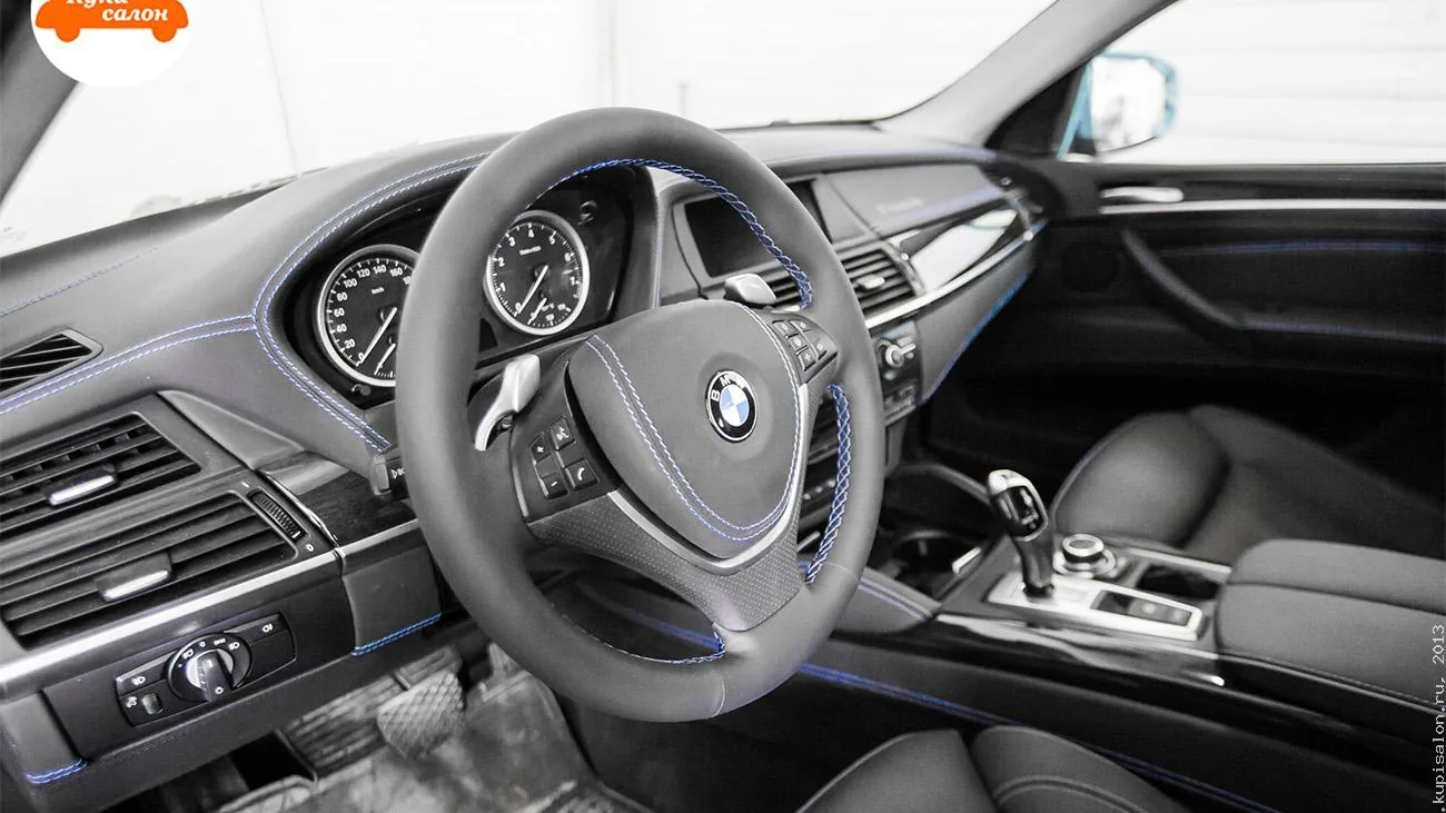 Перетяжка салона BMW X6 черной кожей с синей строчкой, включая руль и торпедо.