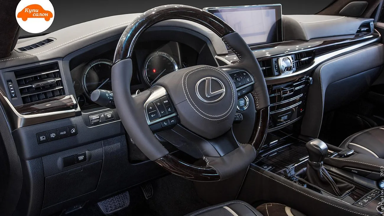 Руль Lexus LX 570: тёмная кожа со светлой строчкой, вставки под дерево, подушка руля с двойной строчкой вокруг эмблемы — фото КупиСалон