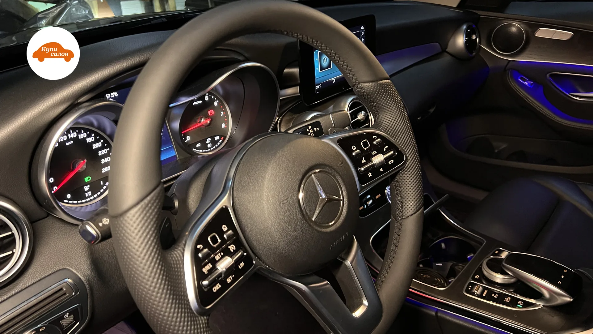 Интерьер Mercedes-Benz с перетянутым рулем из кожи с перфорацией и синей амбиентной подсветкой