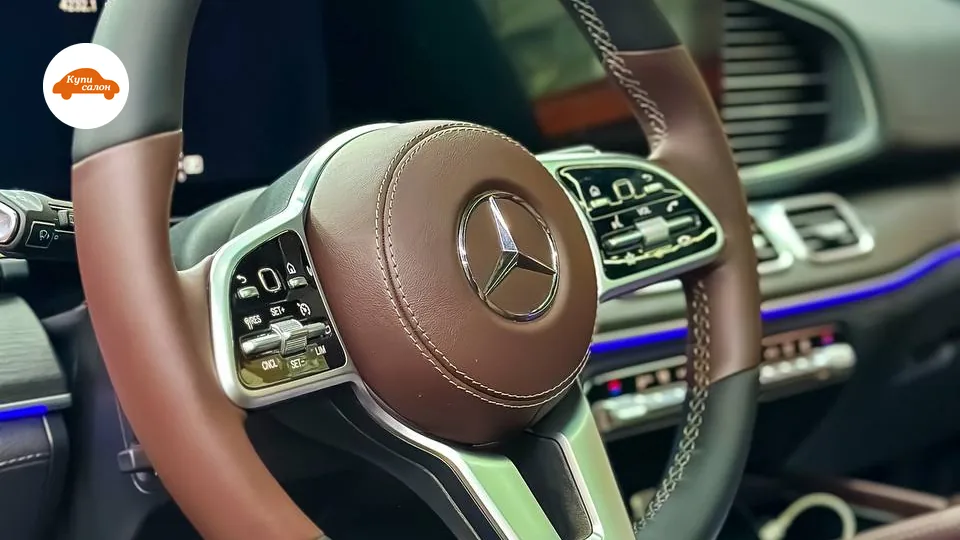Перетяжка руля Mercedes-Benz в коричневую и черную кожу, видны элементы амбиентной подсветки салона