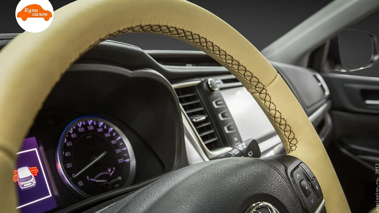 Перетяжка руля бежевой экокожей с черной строчкой в салоне автомобиля Toyota