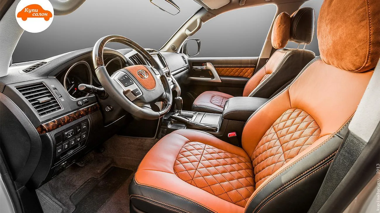 Водительское место Toyota Land Cruiser 200: перетянутый руль с терракотовой вставкой подушки руля и кресла с ромбовидной стёжкой — работа КупиСалон