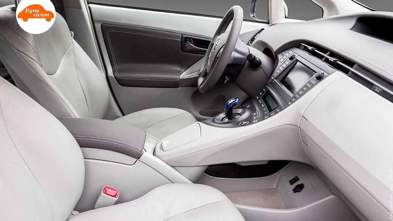 Перетяжка салона Toyota Prius в светлую кожу с перфорацией и серой строчкой, вид спереди.