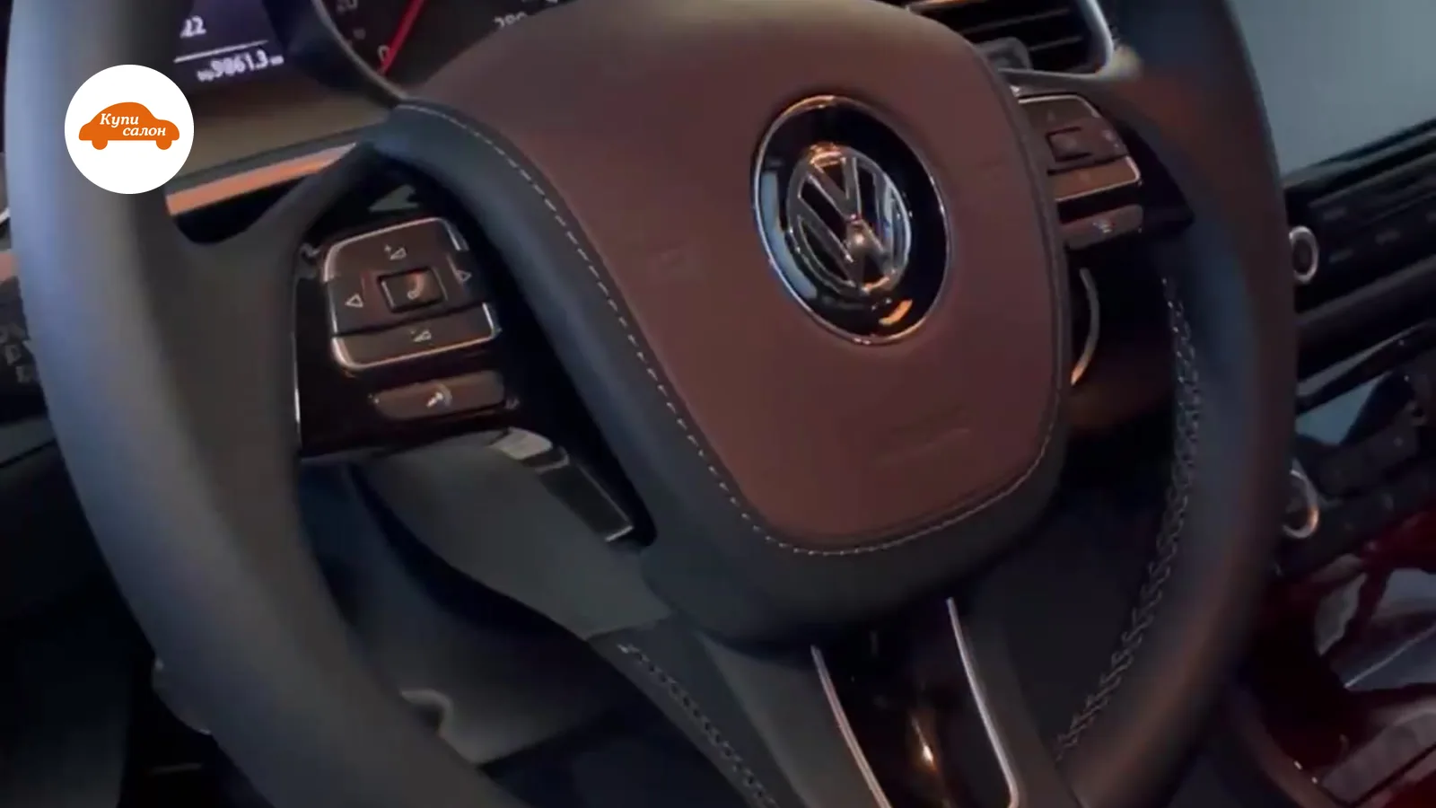 Интерьер Volkswagen Touareg с перетянутым рулем в коричневую кожу с черными вставками и белой строчкой