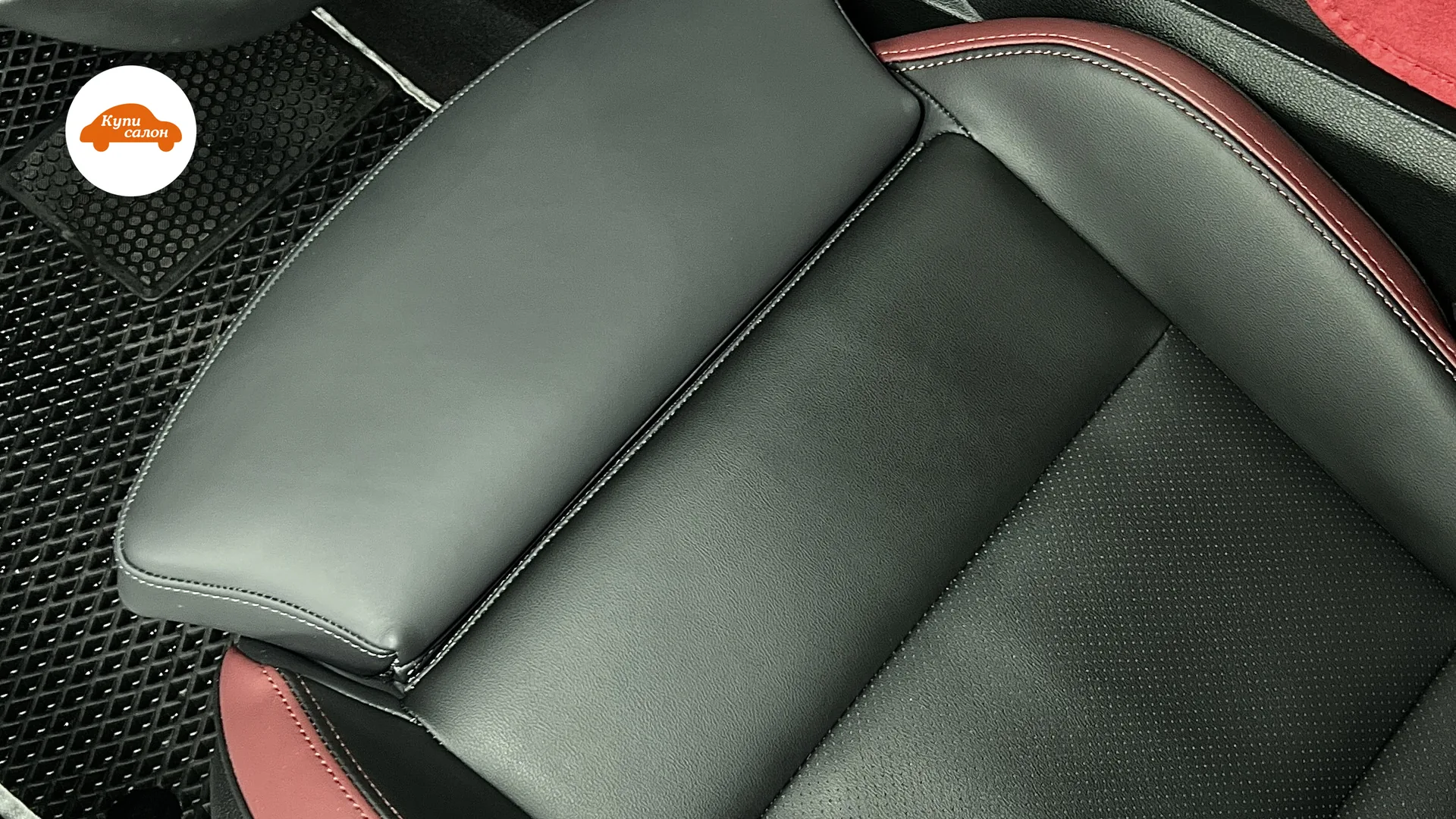 Перетяжка сидений и руля в автомобиле Geely. Сиденья из черной перфорированной кожи с красными вставками, руль из черной кожи.