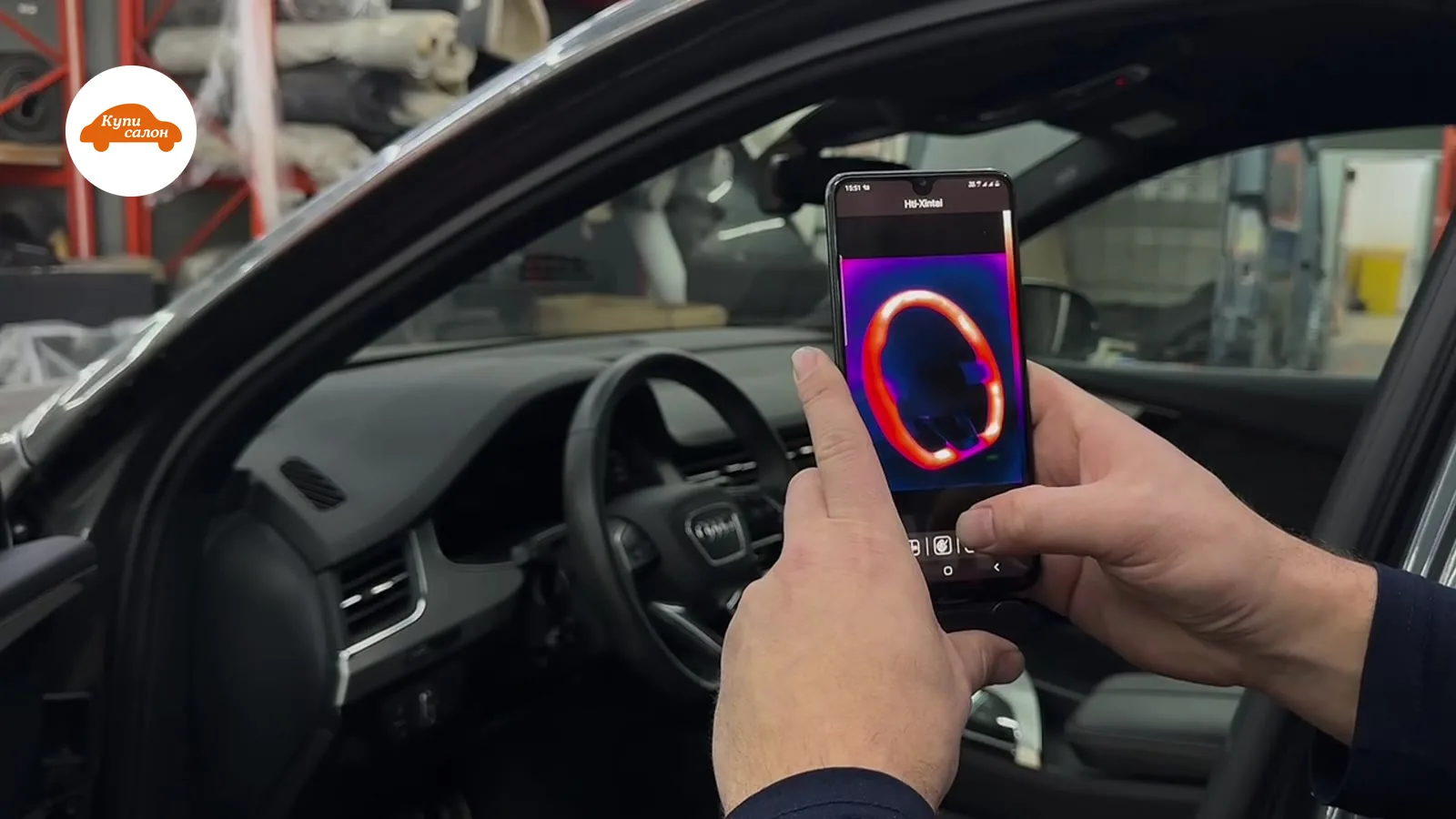 Подогрев руля Audi — водительская зона с телефоном, показывающим термограмму руля