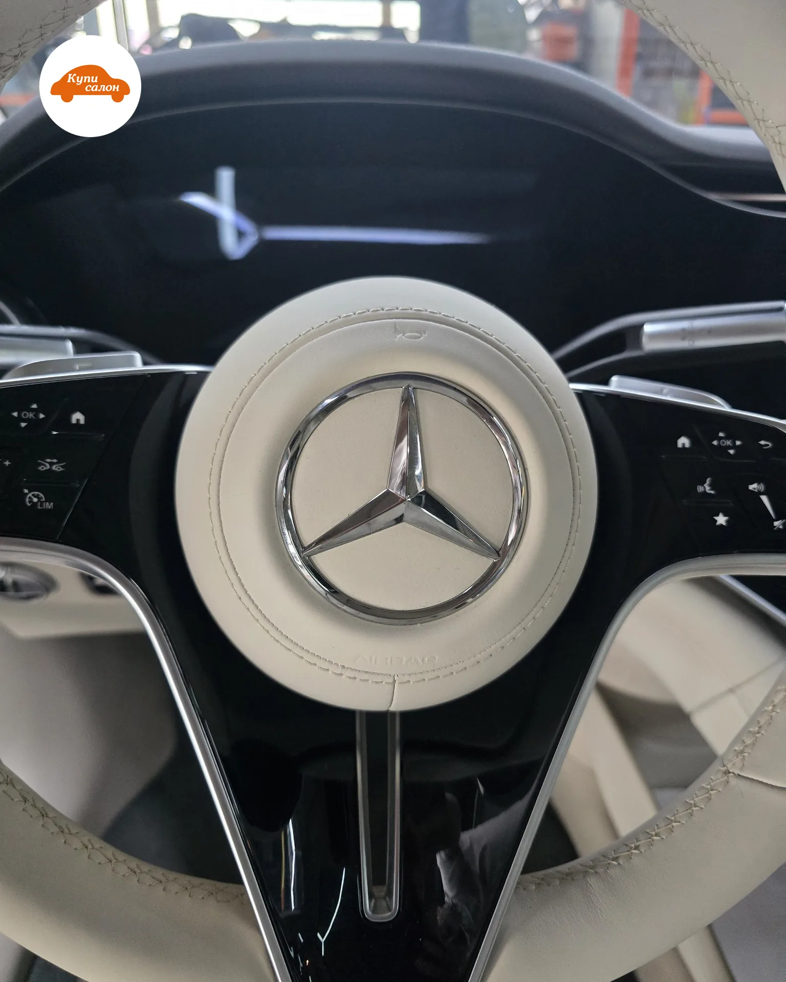Подушка руля Mercedes EQS 580 после перетяжки натуральной наппой: звезда, тиснёный значок клаксона сверху и тиснёная надпись AIRBAG снизу
