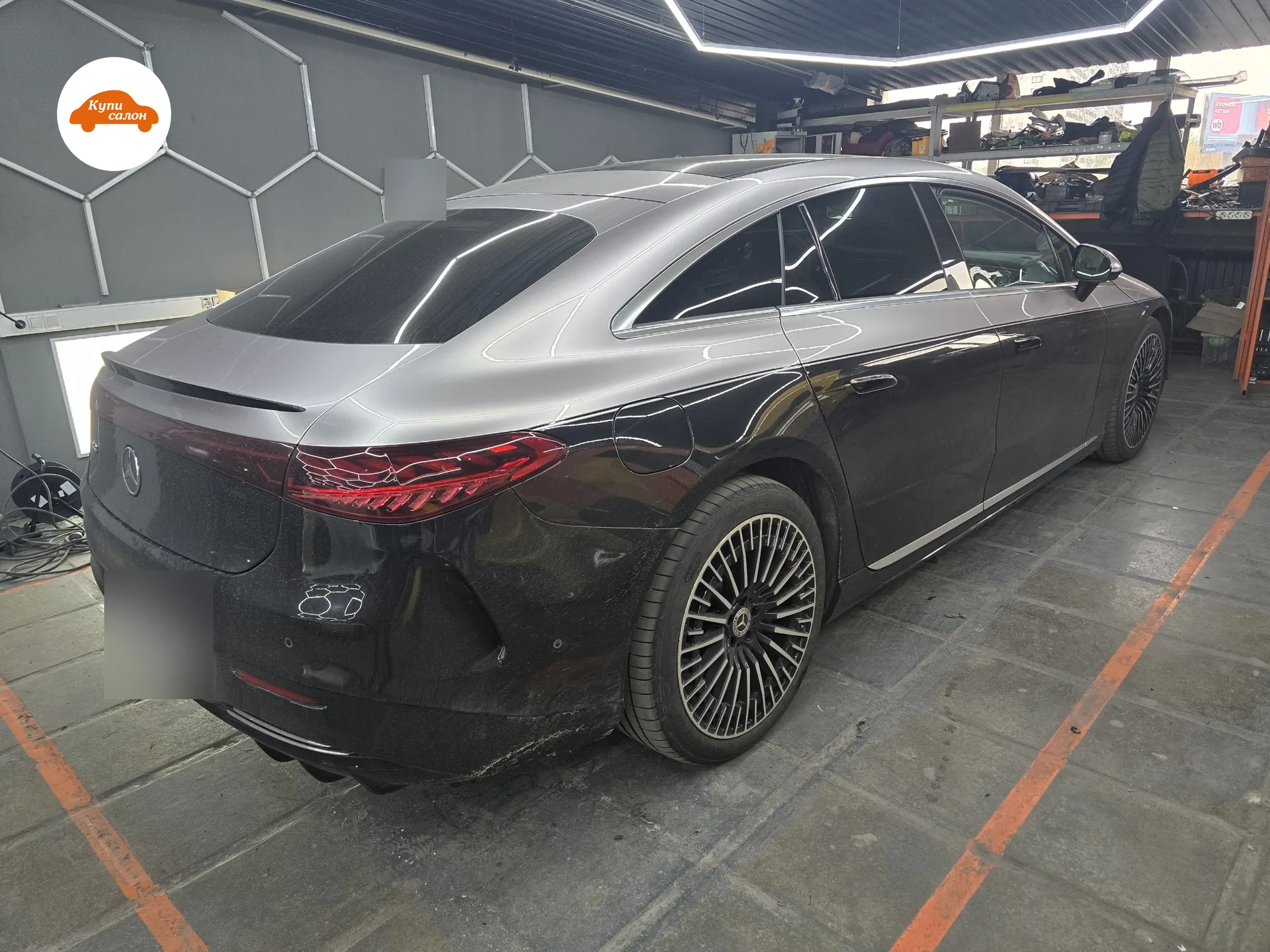 Mercedes EQS 580 в цехе КупиСалона перед работой по подогреву и перетяжке руля, вид сзади сбоку, госномер закрыт