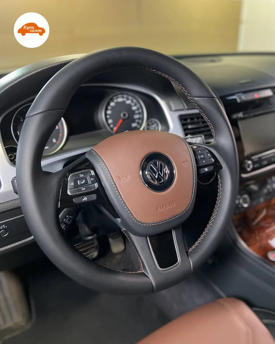 Руль Volkswagen Touareg второго поколения: обод в чёрной коже с коричневой строчкой, подушка с коричневой вставкой, блоки кнопок на спицах