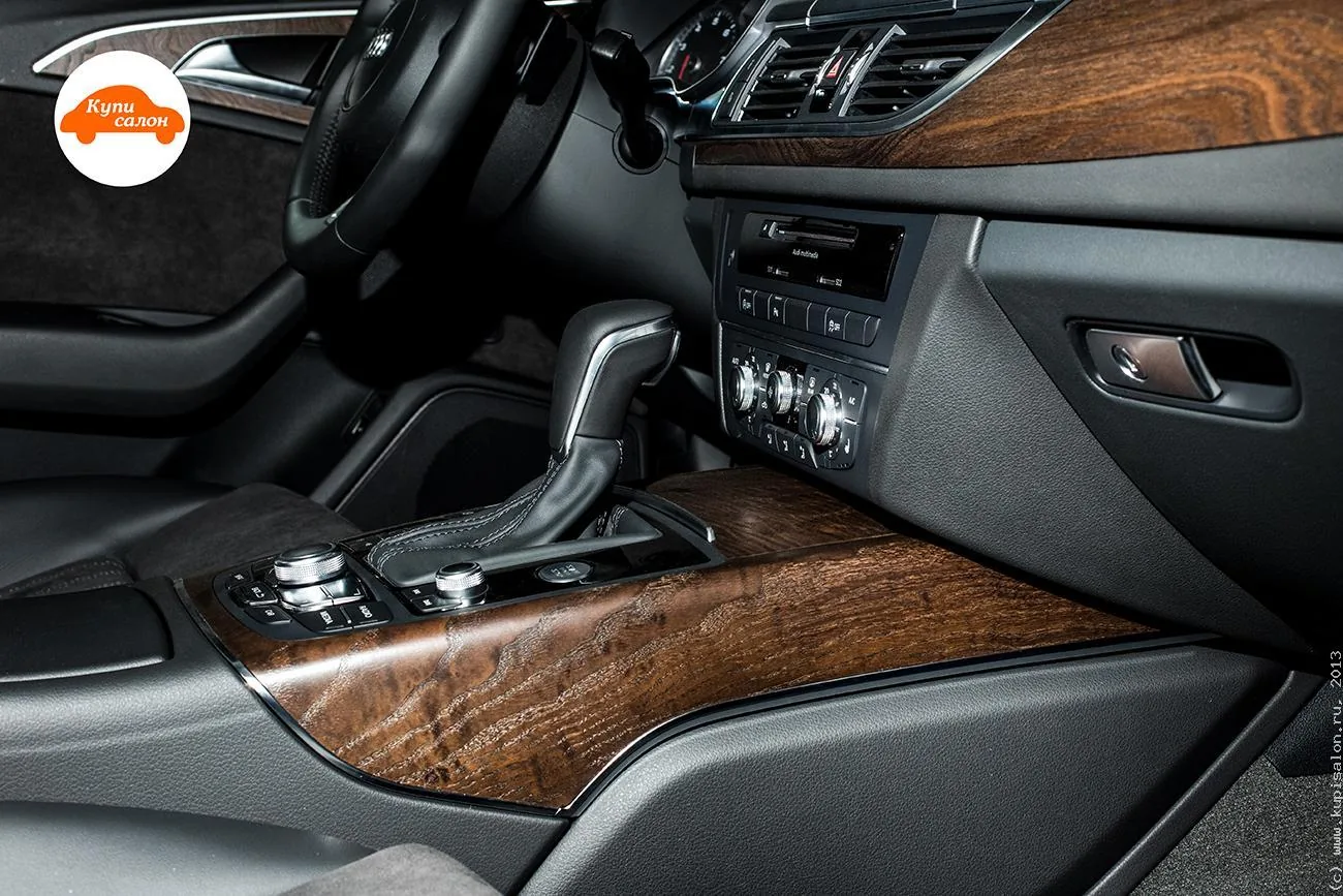 Центральная консоль Audi A6: под панелью мультимедиа со слотом для дисков ряд клавиш, ниже блок климата с тремя регуляторами, на тоннеле селектор и отделка под дерево