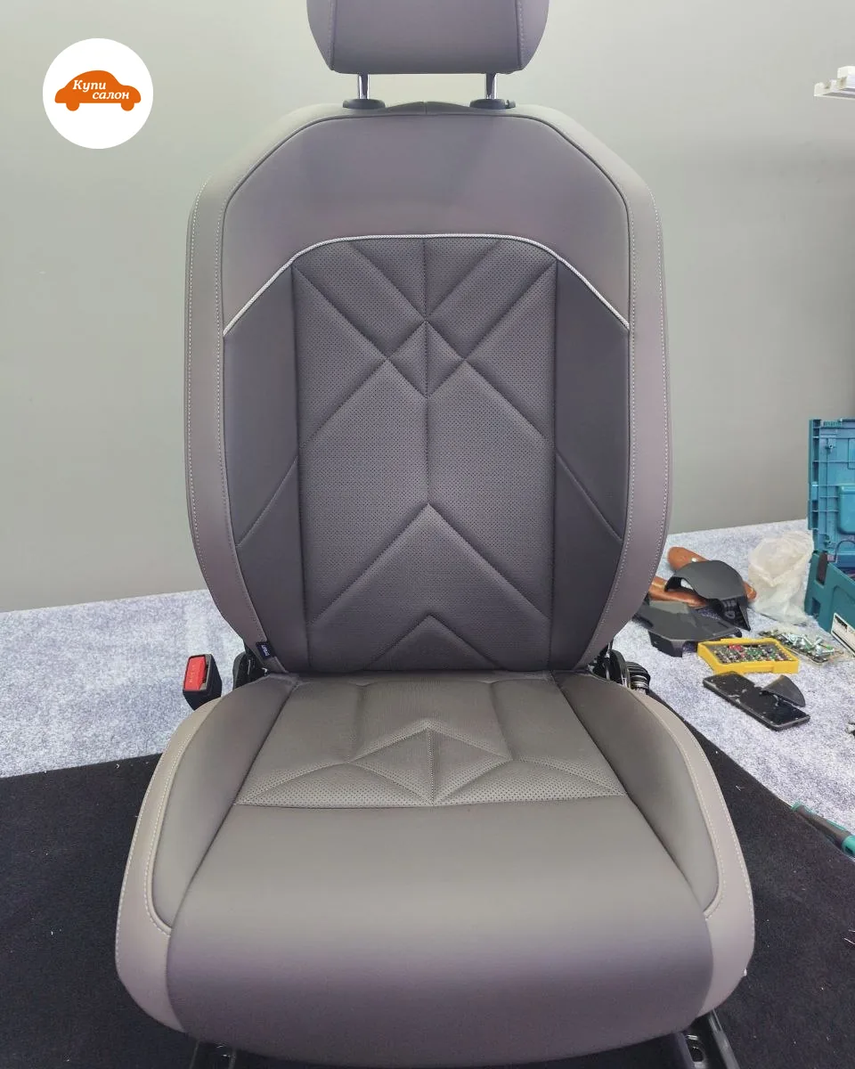Переднее кресло BMW X3 (G48) на верстаке в мастерской: серая обивка, на спинке тёмная перфорированная вставка с геометрической отстрочкой, на подушке перфорированная вставка с отстрочкой в тон обивки