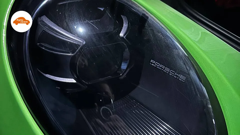 Фара Porsche с защитной пленкой, зеленый цвет кузова, коробки в багажнике.