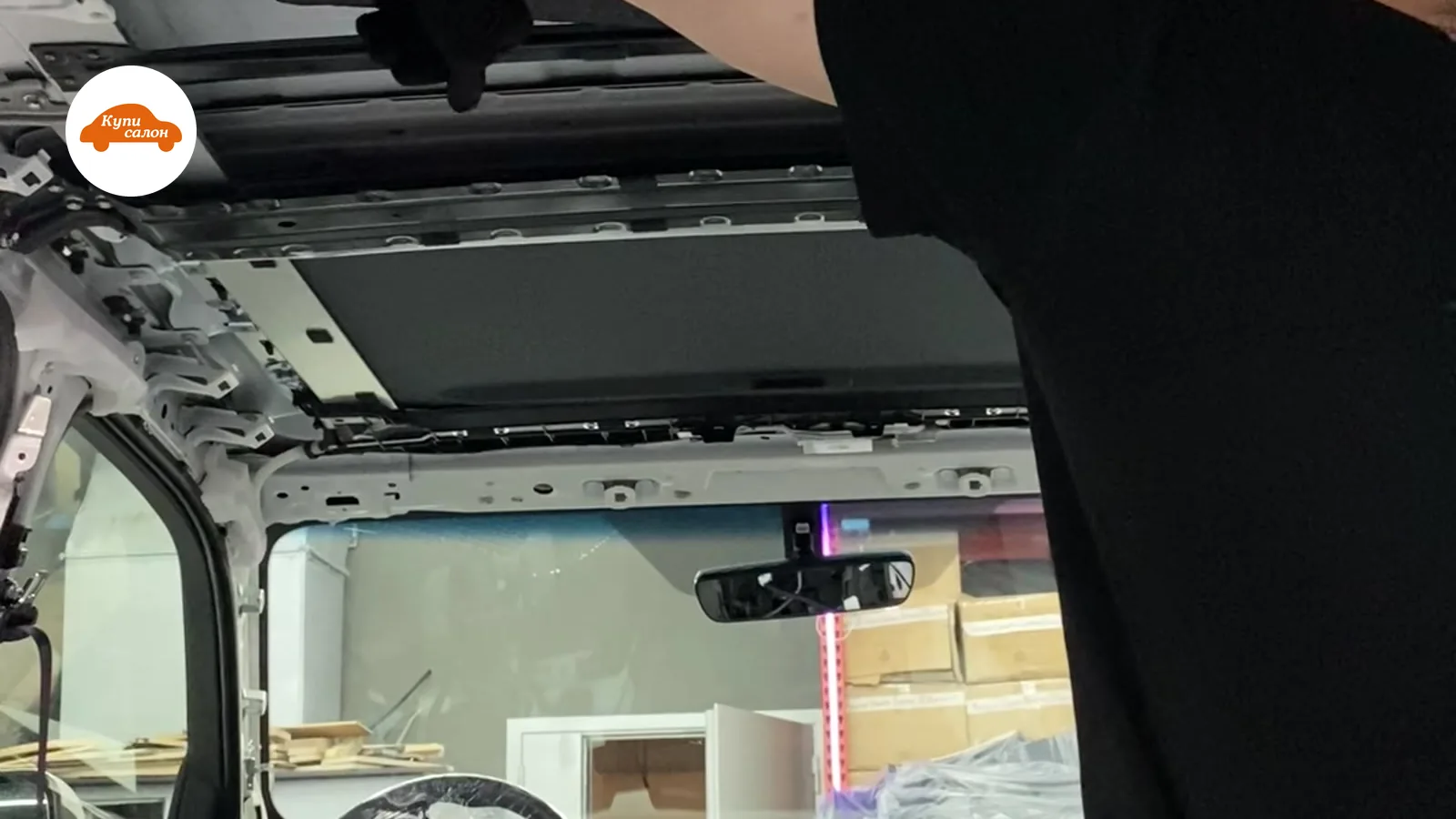 Шумоизоляция потолка автомобиля, видны элементы салона и руль в защитной пленке.