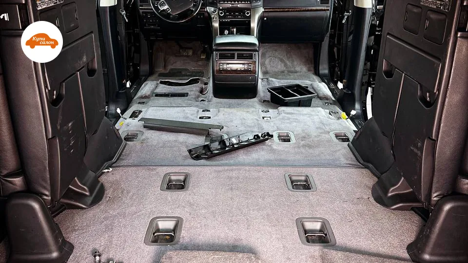 Разобранный салон Toyota Land Cruiser 200 для шумоизоляции, видны элементы крепления сидений и центральная консоль.