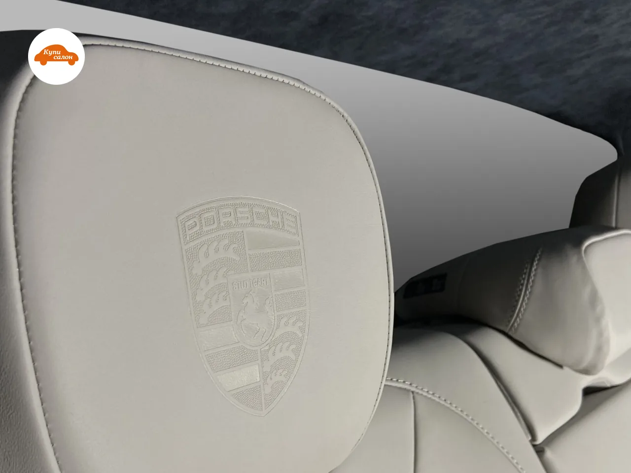 Герб Porsche выдавлен на переднем подголовнике из светло-серой кожи