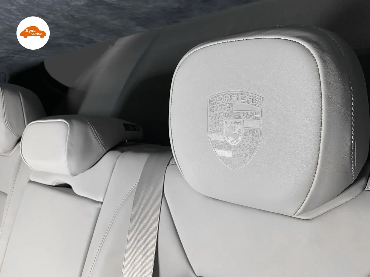 Герб Porsche выдавлен на заднем подголовнике из светло-серой кожи