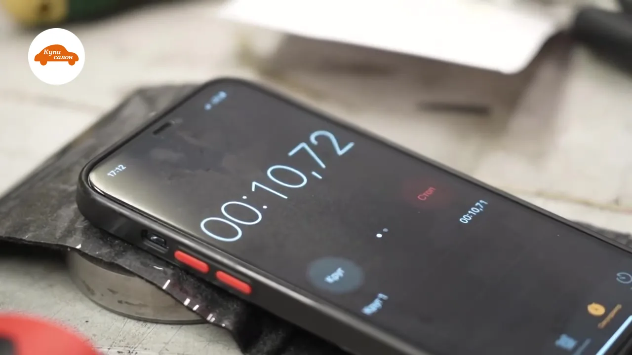 Секундомер на телефоне у пресса показывает 00:10,72 — время выдержки при тиснении