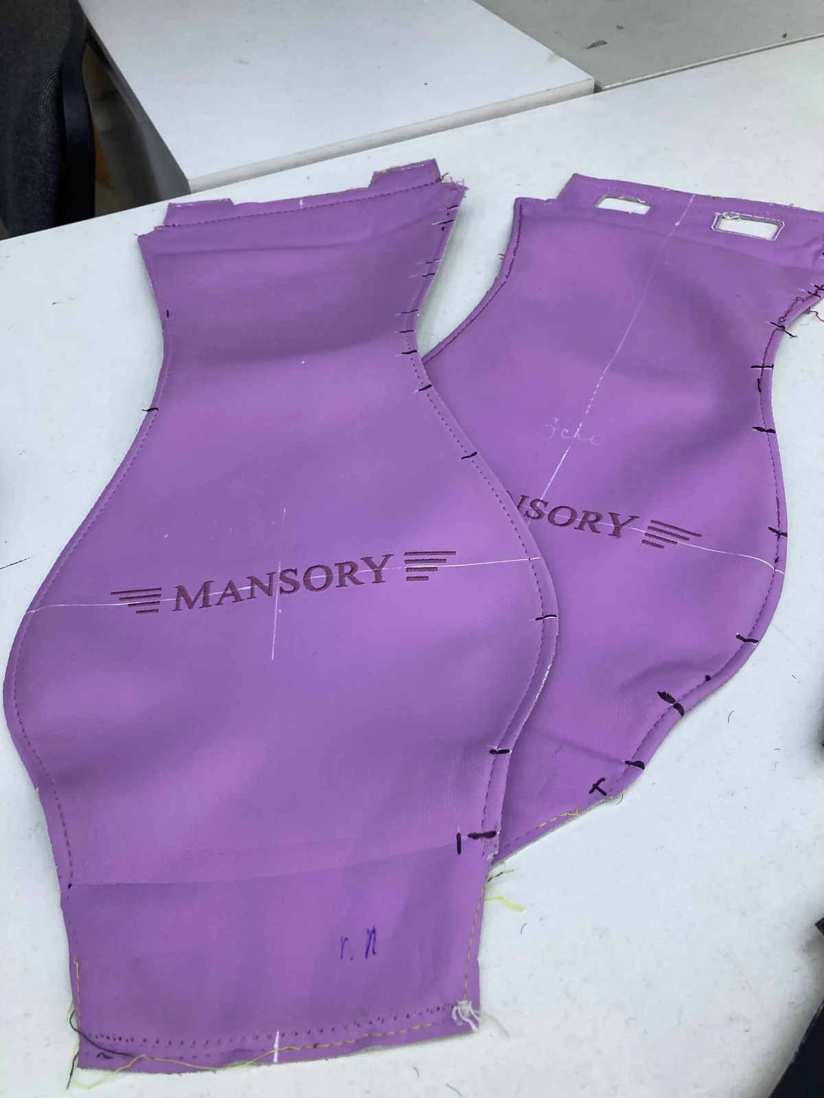 Вышивка логотипа MANSORY в тон на выкройках из сиреневой гладкой кожи