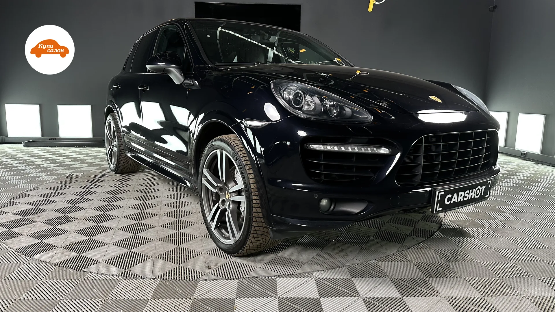 Porsche Cayenne — Чёрный Porsche Cayenne в студии автоателье на сером полу с узором