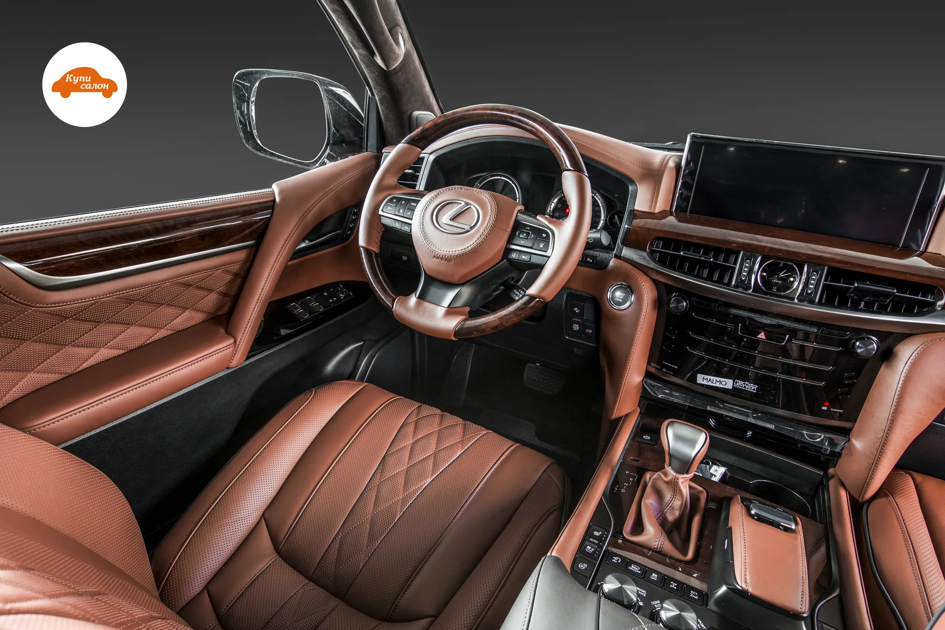 Lexus LX — Салон Lexus LX: коричневая кожа с ромбовидной прострочкой и перфорацией на сиденьях, деревянные вставки, алькантара на потолке